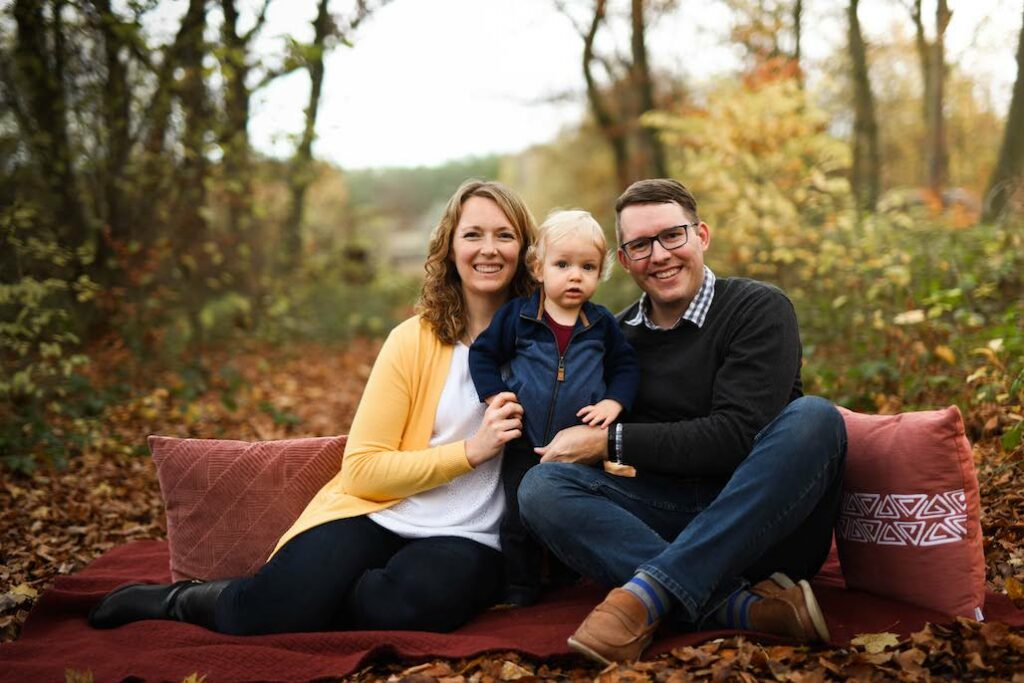 Professional photo of Ellie, Alex, and Orion surrounded by fall leaves